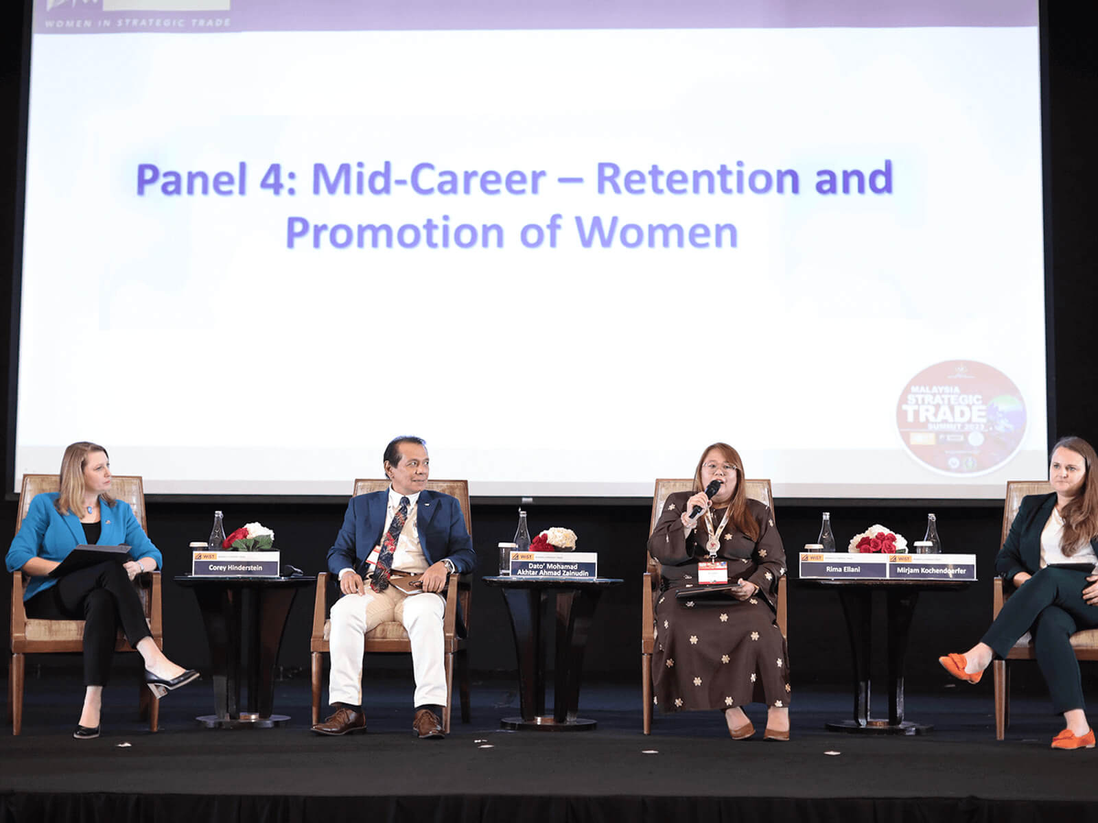 A panel of people sitting on stage